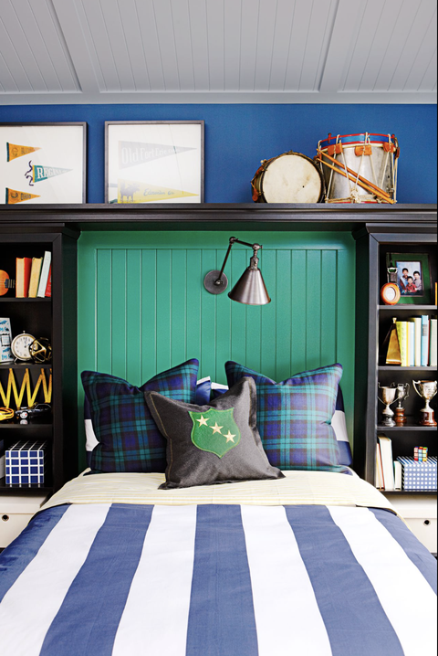 bedroom ideas, bed surrounded by shelves full of books with ba green backdrop and light