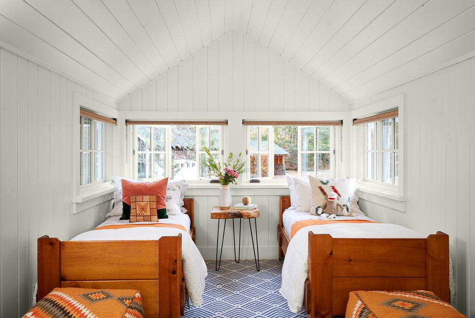 lakeside cabin in wisconsin that has a white attic bedroom with two twin beds