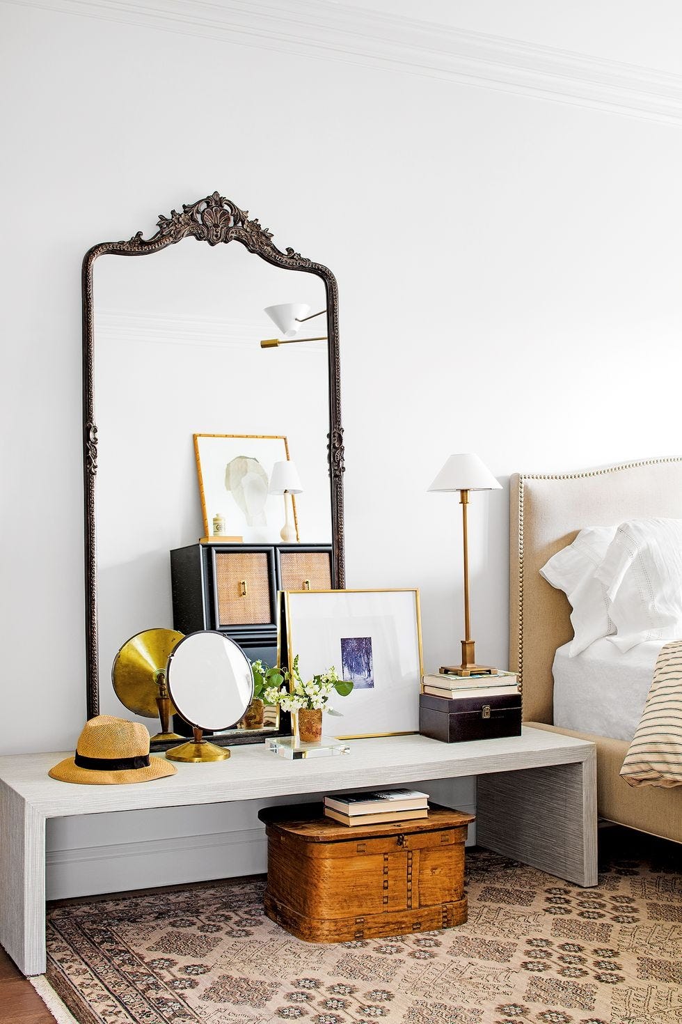 bedroom storage ideas, console table by bed with a mirror and trinkets on top