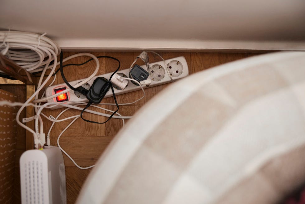 plugs in extension cord behind sofa