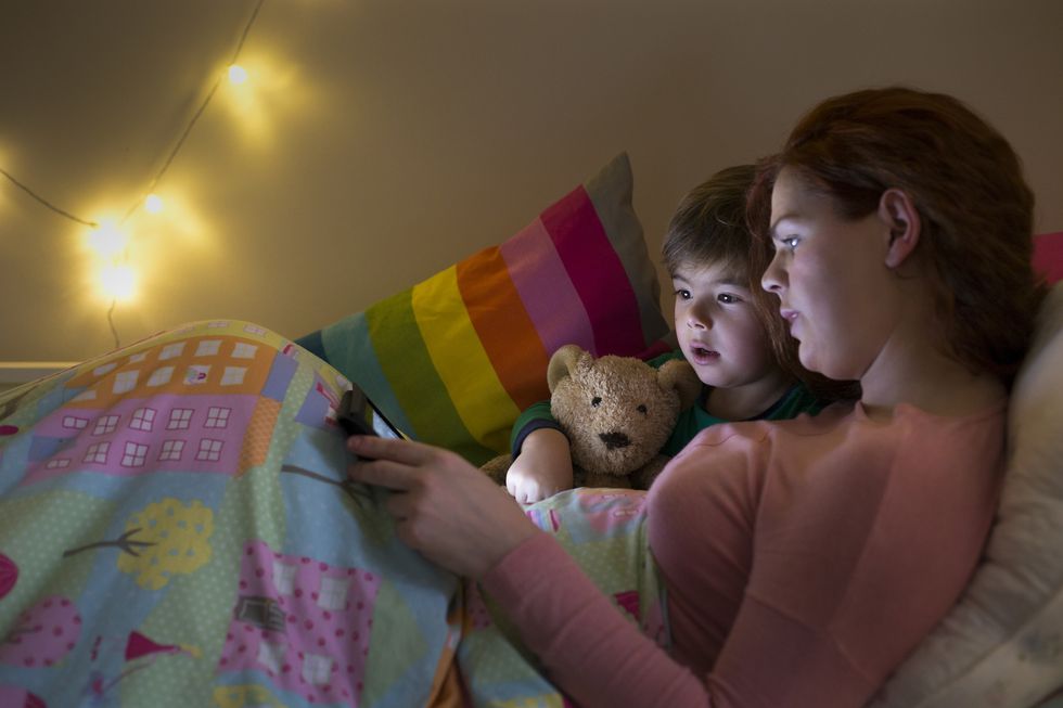 leer cuentos a los niños pequeños sobre sus miedos, como hace la madre en la foto, es una buena solución para evitar las pesadillas nocturnas
