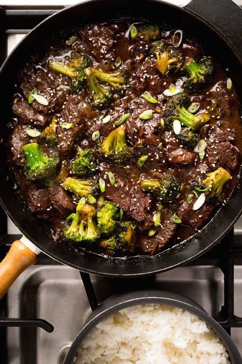 beef and broccoli in a pan with a side of white rice