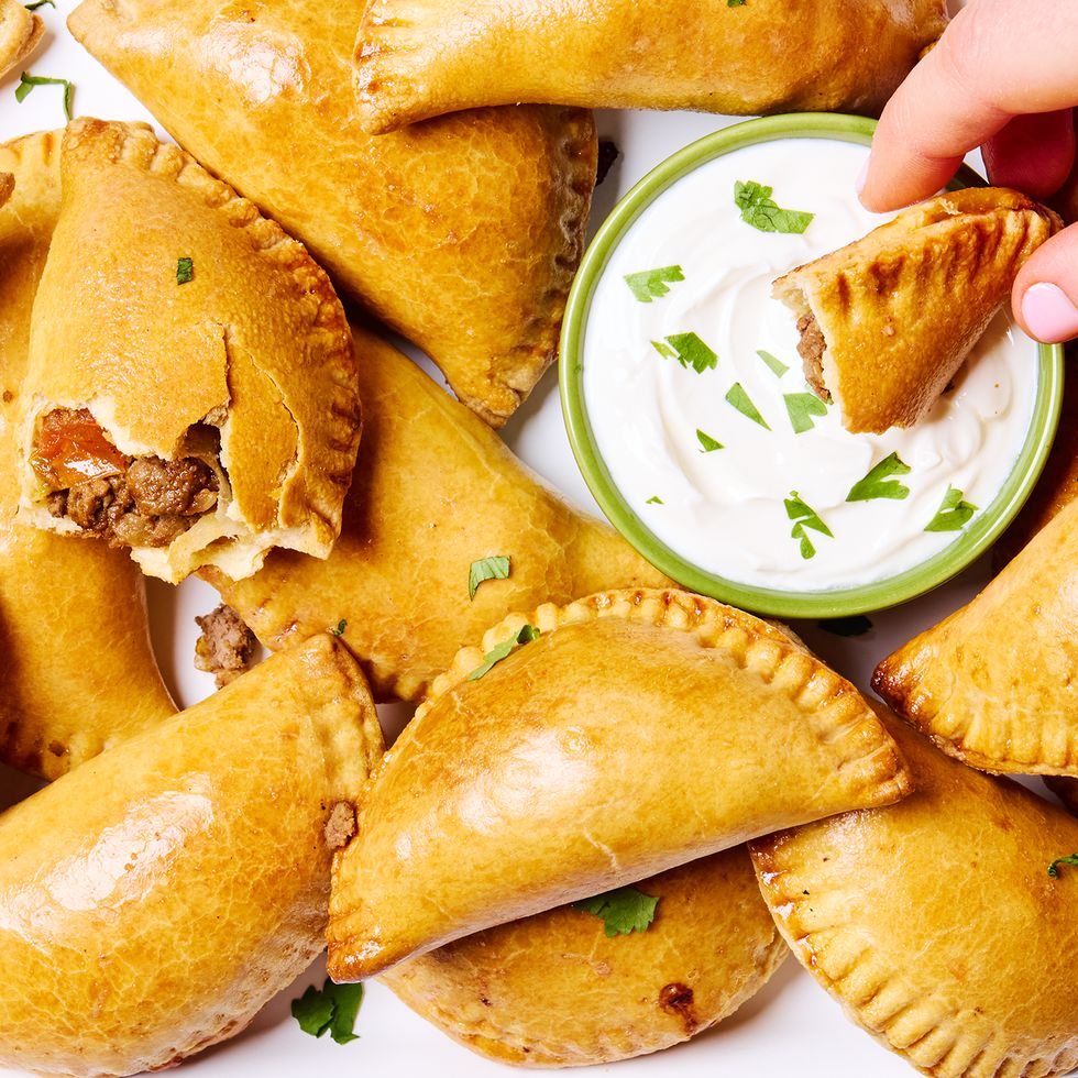 golden brown beef filled empanadas with a creamy dipping sauce