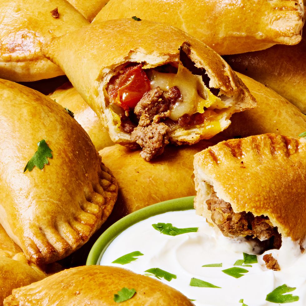 empanadas torn open with a beef, cheese, and tomato filling