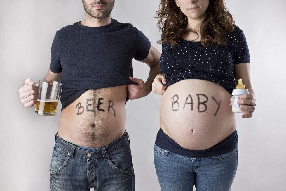 un hombre con barriga cervecera y una mujer embarazada