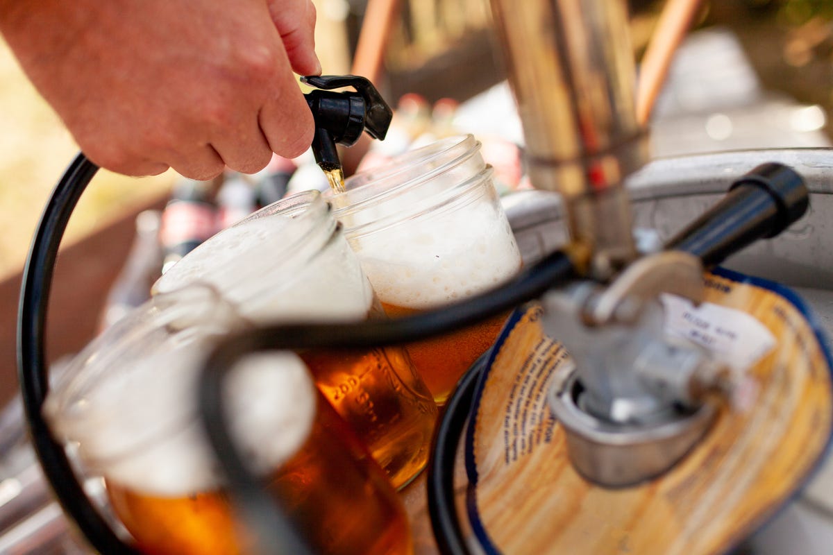 beer being pourn into mason jar from keg