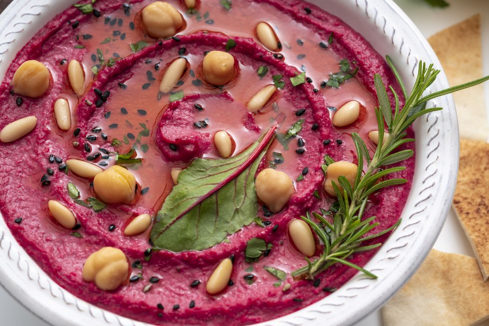 beet beetroot hummus bowl closeup with pita flatbread dipping isolated on white
