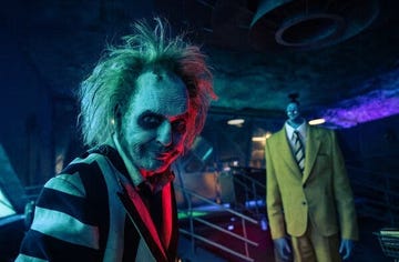 beetlejuice stands in front of a shrunkenheaded bob, smirking, in a scene from beetlejuice beetlejuice