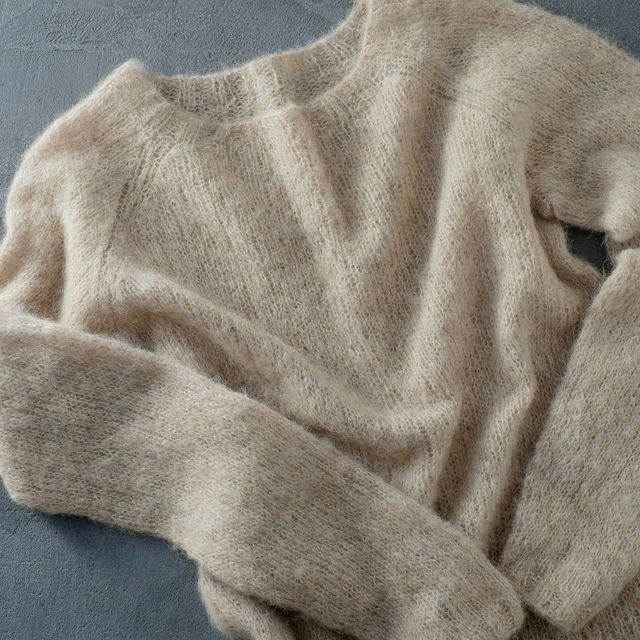 beige knitted woolen sweater on a hanger
