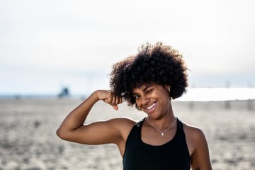 vrouw op het strand laat haar biceps zien