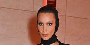 bella hadid attends exhibition opening at the museum of islamic art wearing black dress and head covering