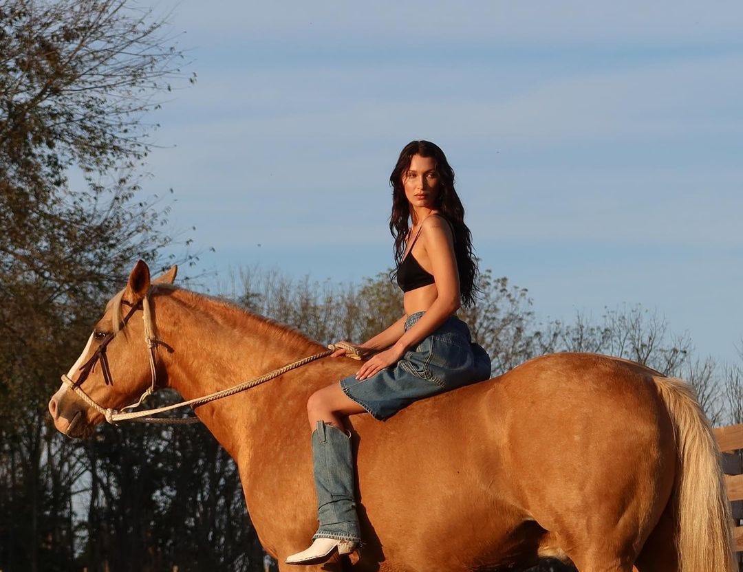 Bella Hadid riding a horse during a photoshoot