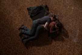 ellie and dina in an intimate embrace on a textured floor in the last of us season 2