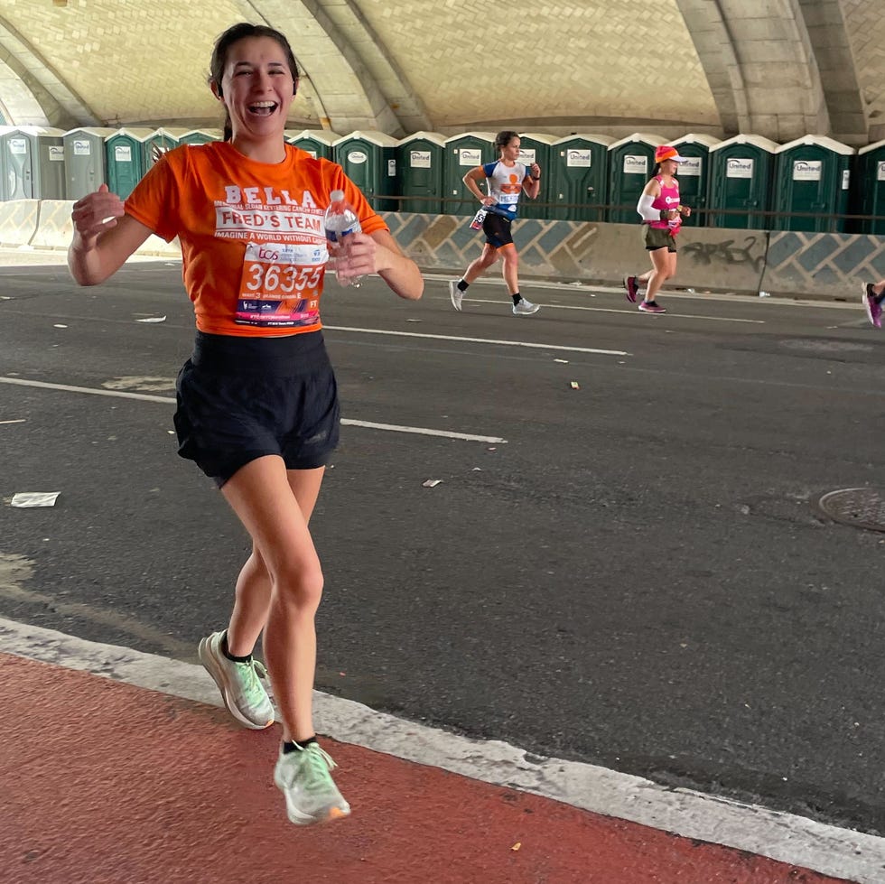 best running shoes for women — testing the Hoka Mach x runner in the nyc marathon wearing the hoka mach x sneakers and an orange shirt for charity