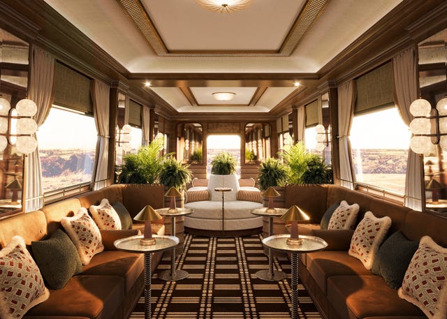 luxurious lounge interior of a train carriage with plush seating and large windows