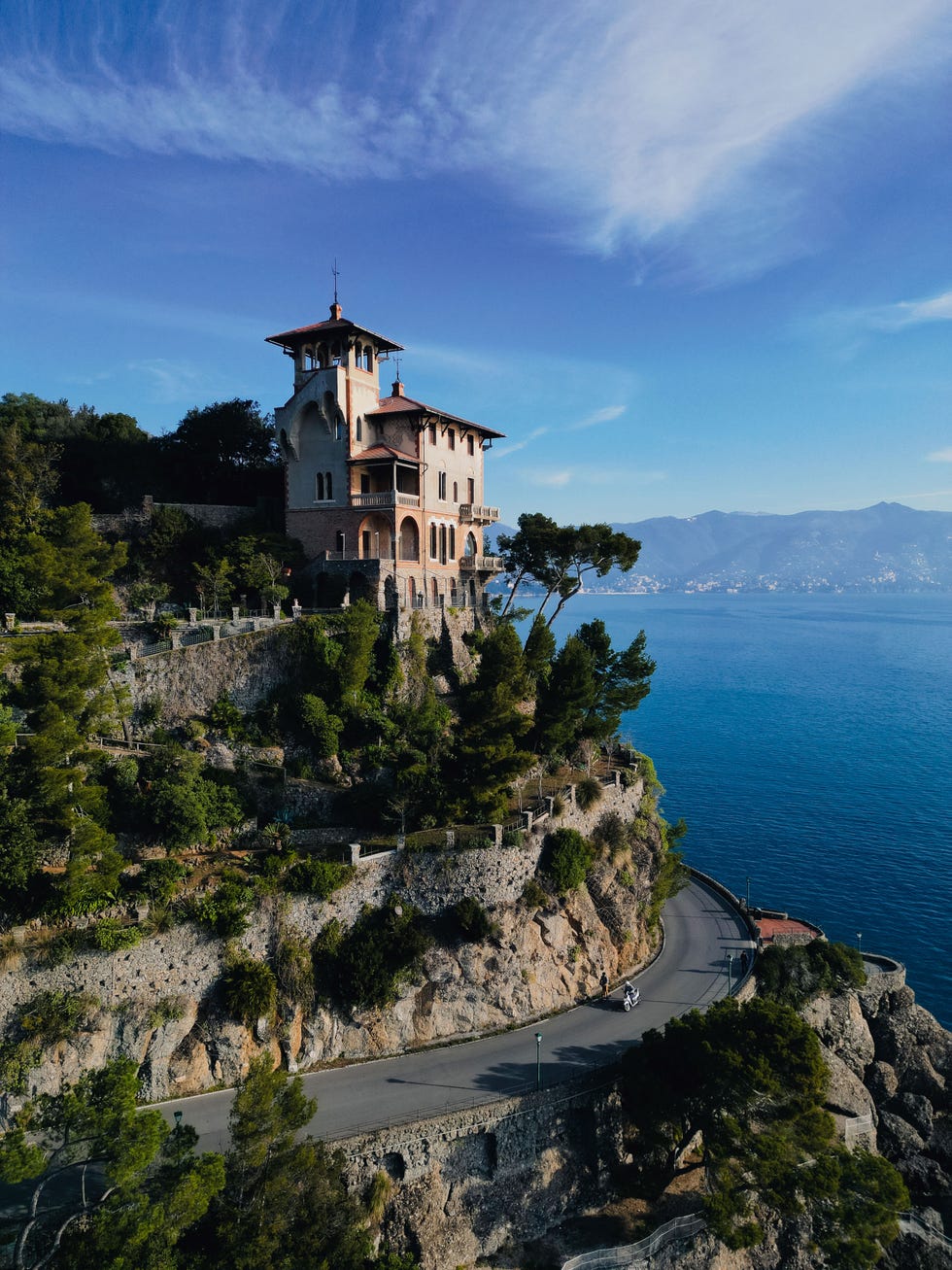 a palazzo stands on a cliff way above the ocean