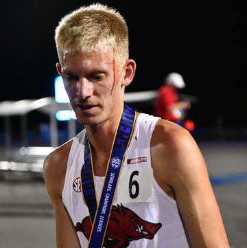 a runner with blood on his face and a silver medal a runner with blood on his face and a silver medal