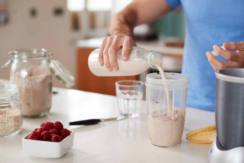 benefits of eating after a workout close up of man making protein shake after exercise at home