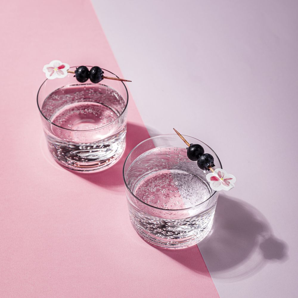 benefits of giving up alcohol studio shot of mocktails with blueberry garnish over pink and lilac background hard light, strong shadows