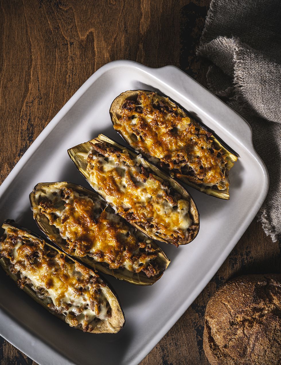 stuffed eggplants with minced meat recipe italian aubergine parmigiana or eggplant parmesan on rustic wood table in an oven tray