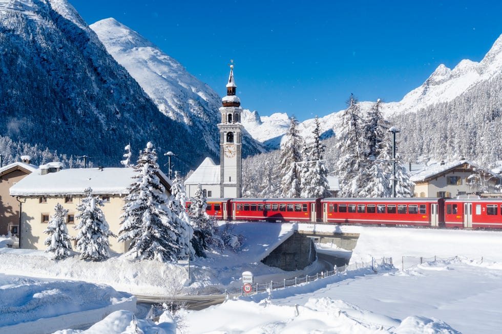 bernina express train along the snow capped village, switzerland