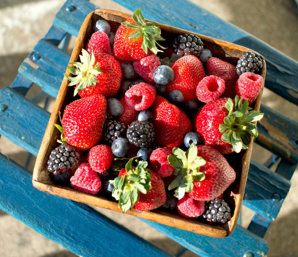 strawberries, raspberries, blueberries, blackberries in a wooden basket