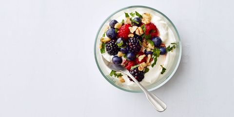 berry yogurt bowl with spoon on a white background