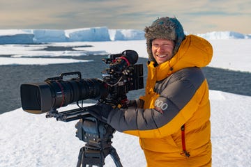 documentairemaker bertie gregory met zijn camera omringd door ijs op antarctica