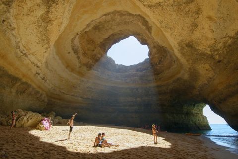Voor de kust van Lagoa Portugal staat een unieke grot genaamd Algar de Benagil Your Shotfotograaf Matilde Viegas maakte deze foto dit toen een lichtstraal door het oog van de grot stroomde en de mensen binnenin verlichtte