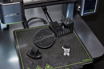 figurines on mat next to 3d printer