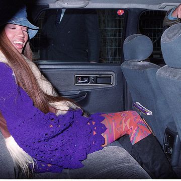 best 90s fashion trends, woman, naomi campbell, in the car smiling while wearing layered attire and a bucket hat
