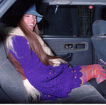 best 90s fashion trends, woman, naomi campbell, in the car smiling while wearing layered attire and a bucket hat