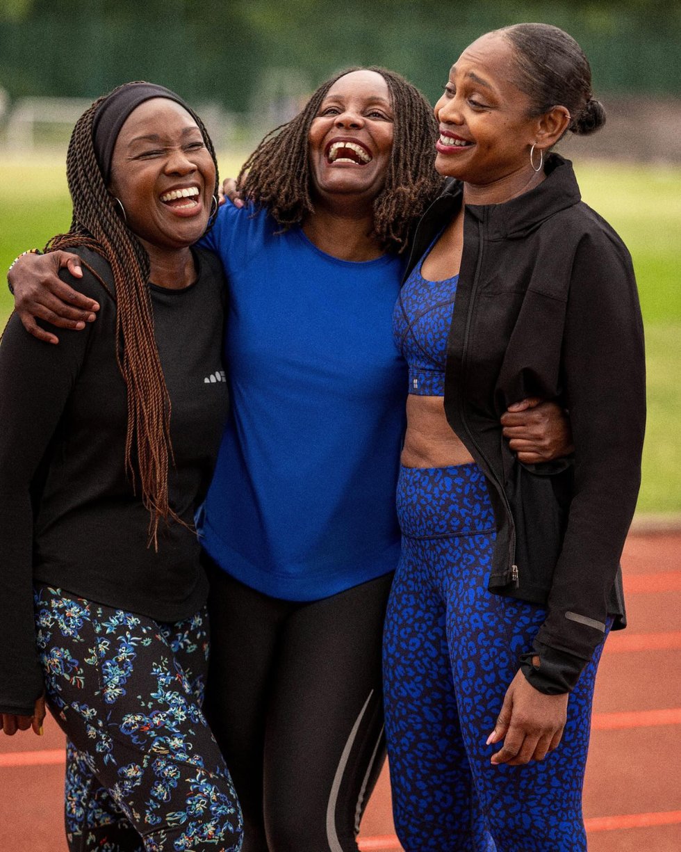 three athletic women posing together on a track field