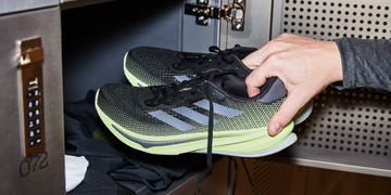 person putting a pair of running shoes into a locker
