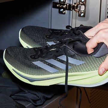 person putting a pair of running shoes into a locker person putting a pair of running shoes into a locker