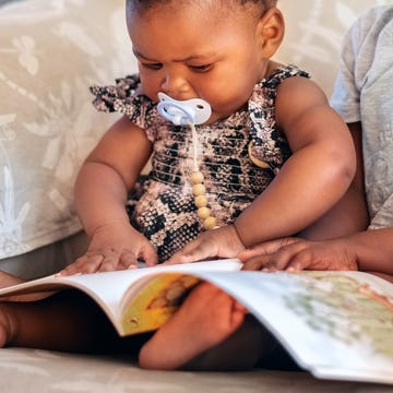 baby and brother reading together in chair