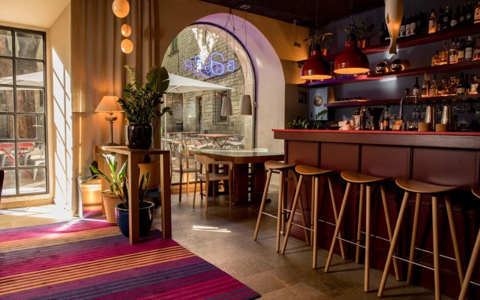 a bar with stools and a rug at hotel neri