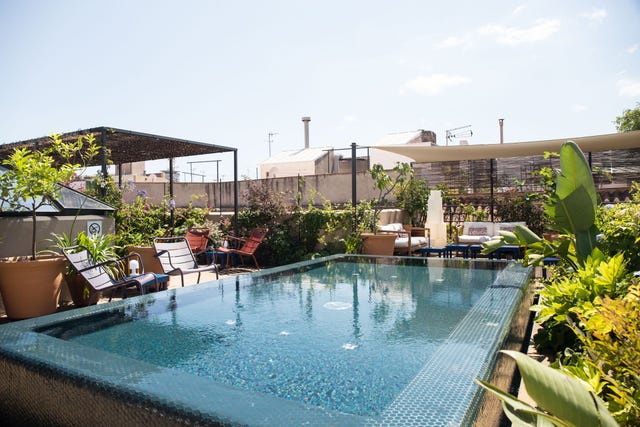 a pool with chairs around it at hotel neri