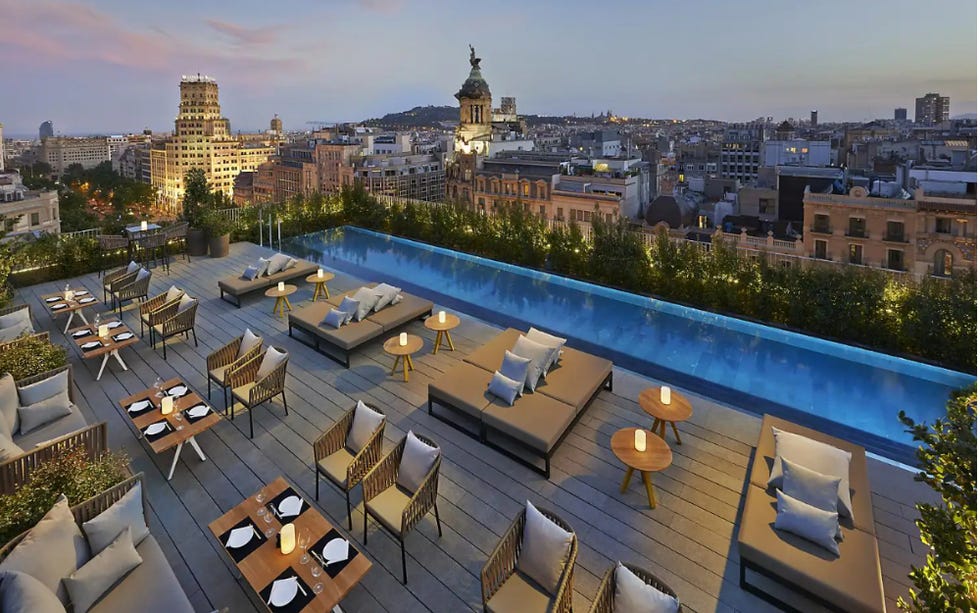 rooftop terrace with seating and infinity pool plus views of the city