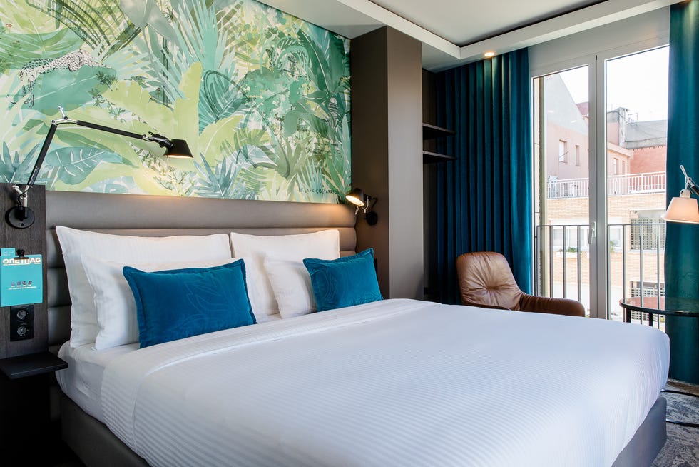 a bed with pillows at motel one barcelona ciutadella