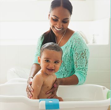 woman bathing her toddler and a few top bath toys