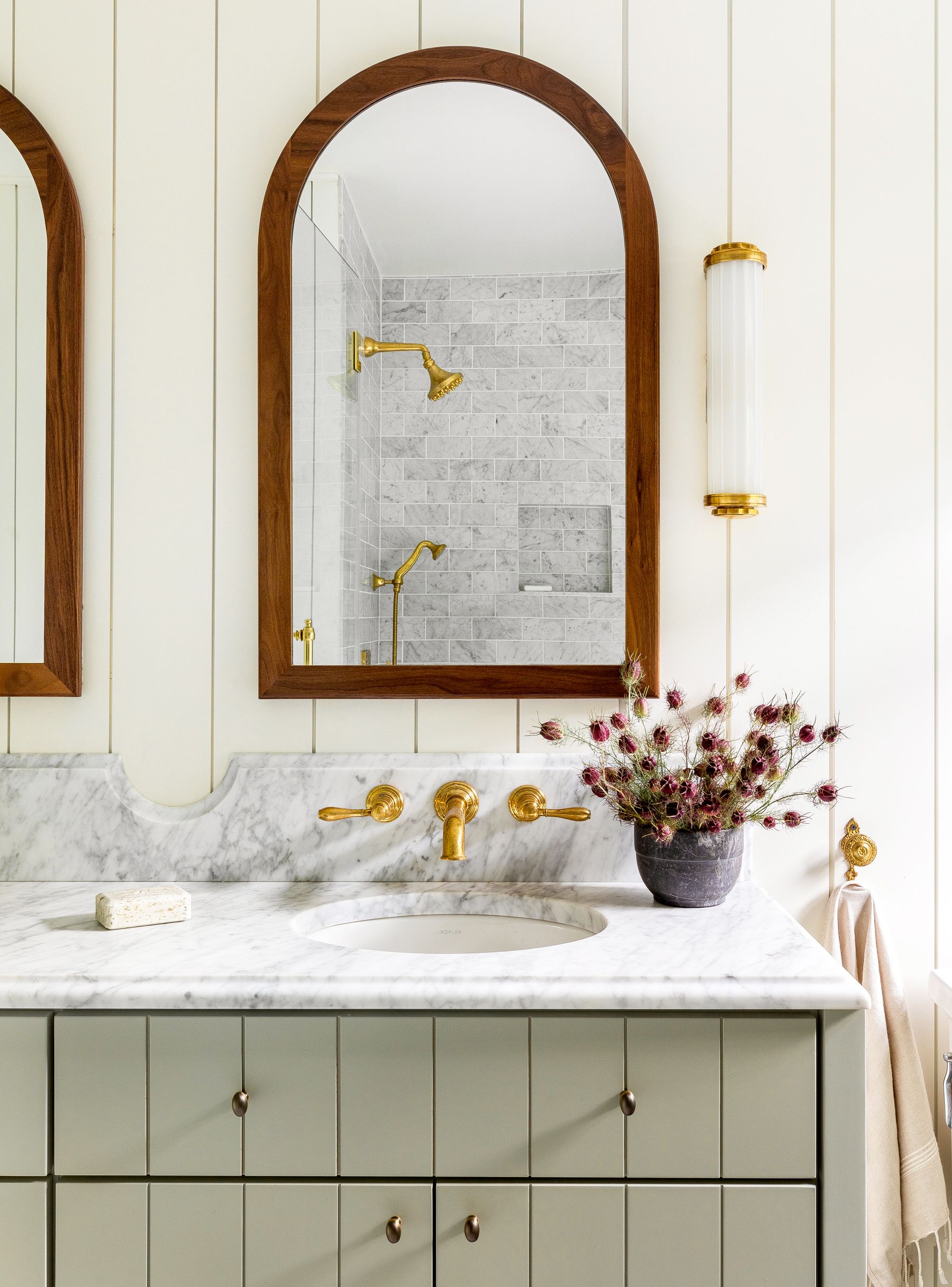 https://hips.hearstapps.com/hmg-prod/images/best-bathroom-lighting-heidi-caillier-design-seattle-interior-designer-arched-medicine-cabinets-green-vanity-vintage-british-eclectic-n28-tudor-master-bathroom-wall-mounted-sink-faucets-marble-countertops-1590685554.jpg