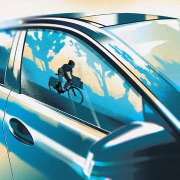cyclist seen in reflection of car window