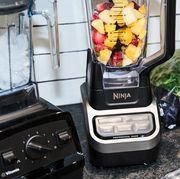 best tested ninja vitamix and nutribullet blenders with frozen fruit ice and kale on counter