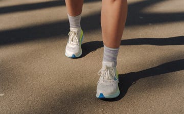 a pair of legs wearing white running shoes