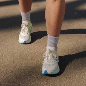 a pair of legs wearing white running shoes a pair of legs wearing white running shoes