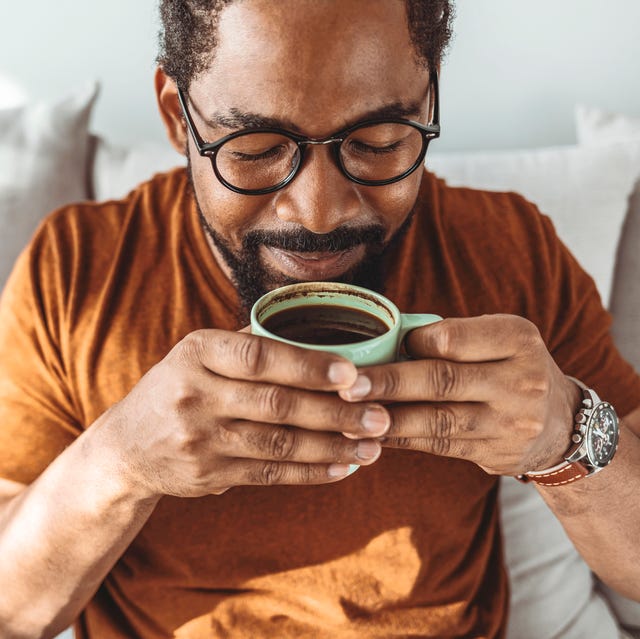 cropped shot of a handsome young man relaxing with a cup of coffee