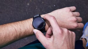 a person checking a black smartwatch on their wrist