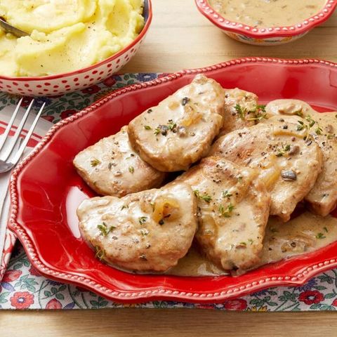 slow cooker pork chops with gravy on red plate
