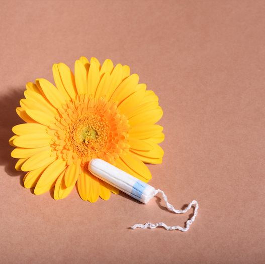 a tampon set against a yellow flower to denote that it is eco friendly